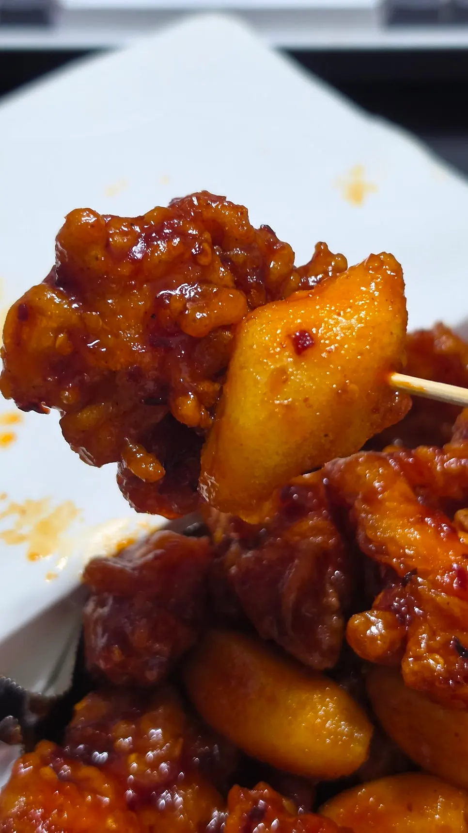 Piece of dakgangjeong coated in spicy sauce