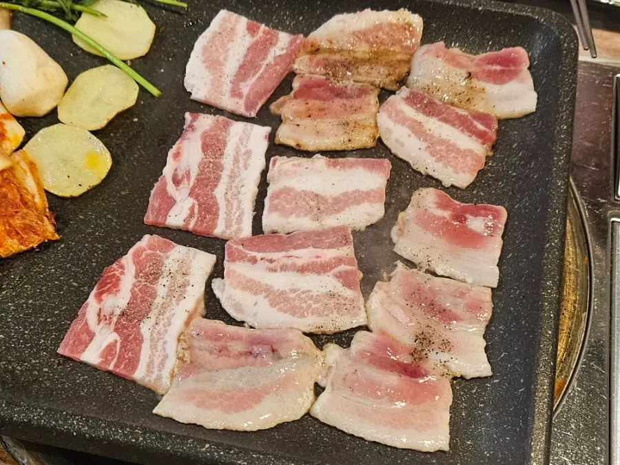 Frozen pork belly grilling on the pan
