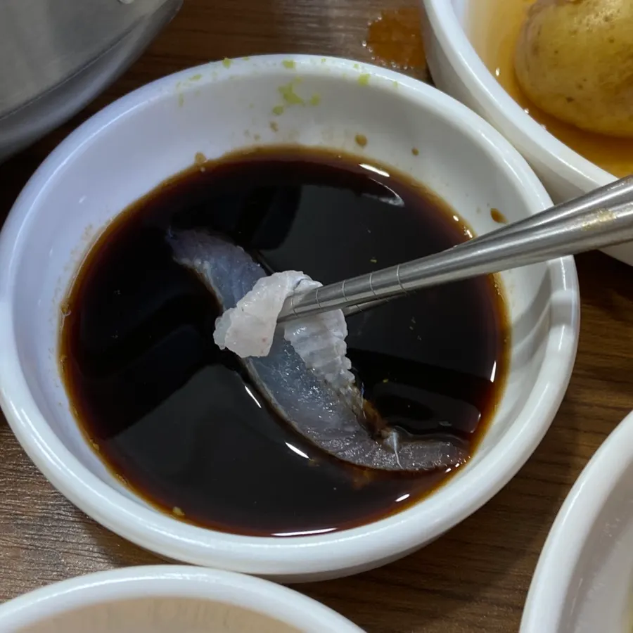 Yellow flatfish sashimi dipped in soy sauce