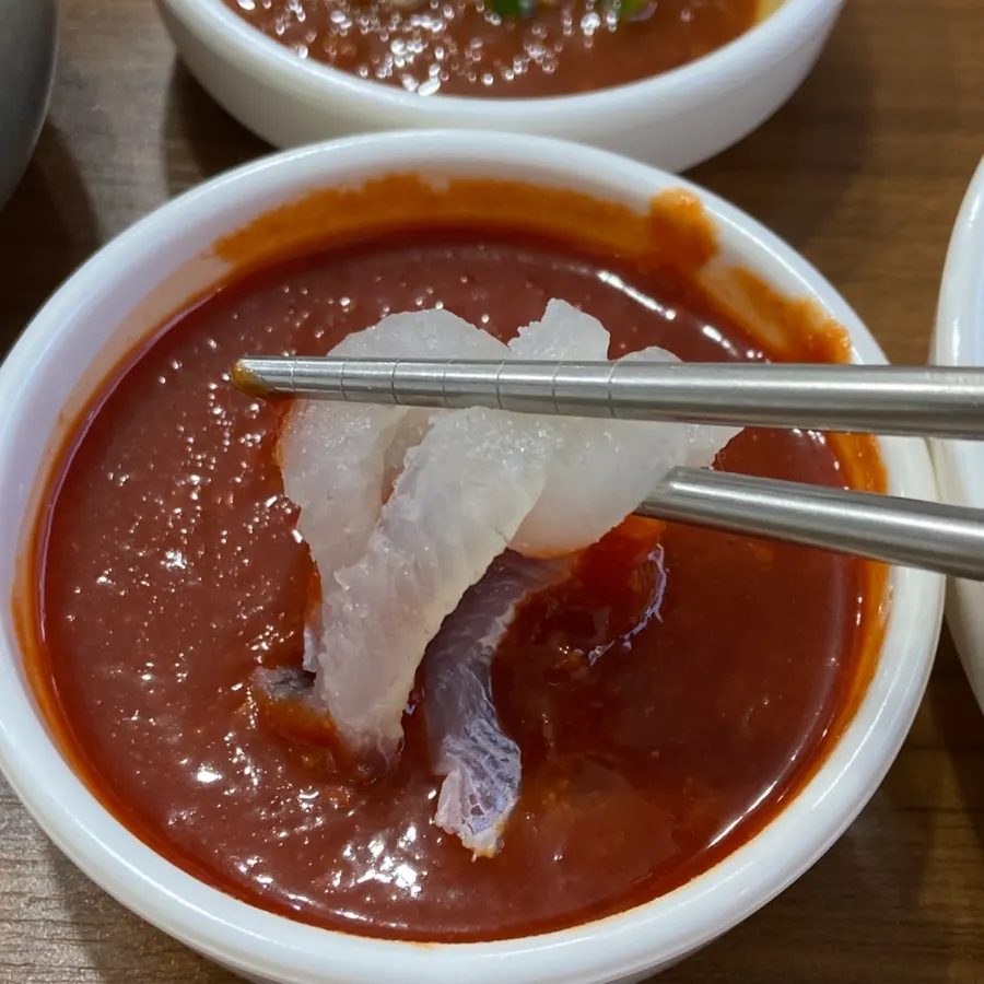 A piece of flatfish sashimi dipped in chojang