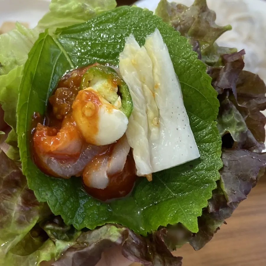 Flatfish sashimi on a lettuce wrap with ssamjang