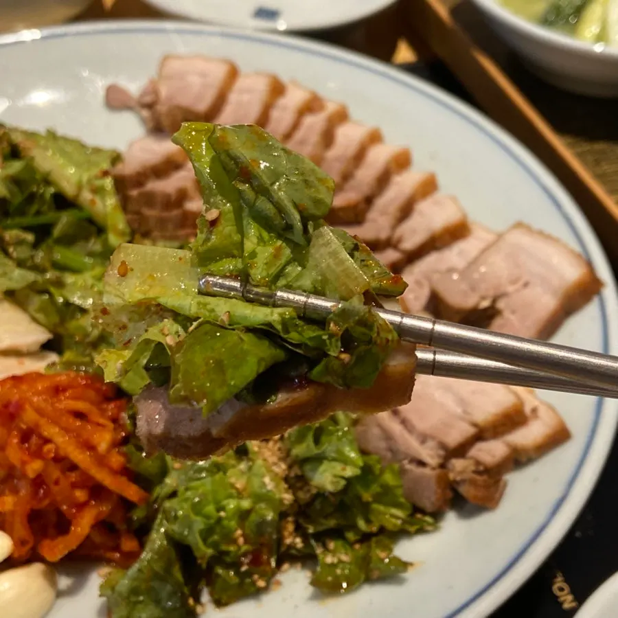 A bite of bossam with kimchi