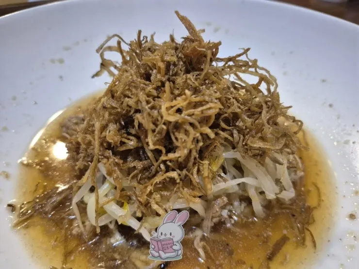 Course dish of bean sprouts layered over meat