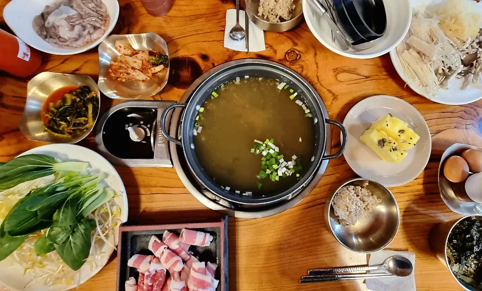 낙지칼국수와 추가 재료가 놓인 테이블