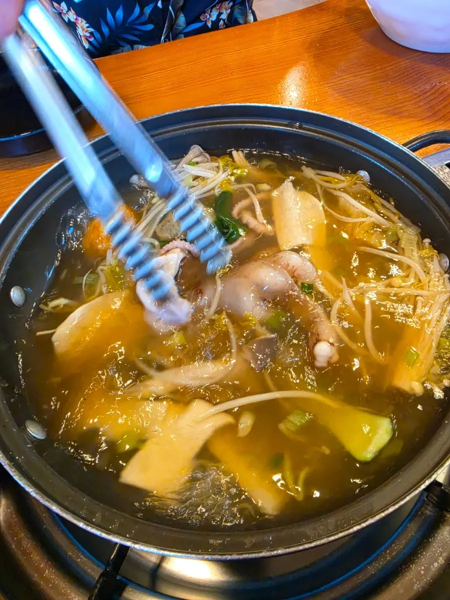 Pot of shabu-shabu simmering with whole octopus