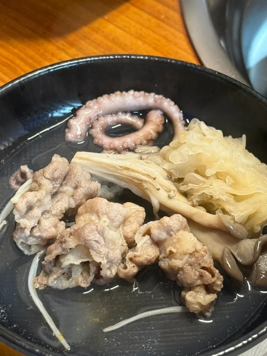 A spoonful of barley rice topped with blanched octopus and beef