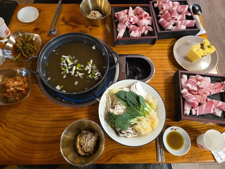 Self-serve corner with broth, kimchi, garlic and cheongyang chili peppers