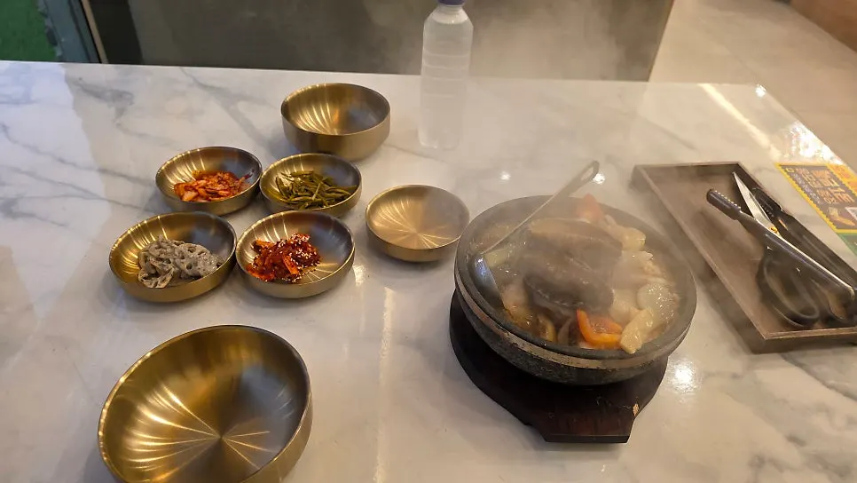 Nurungji-tang topped with abalone, shrimp, and squid