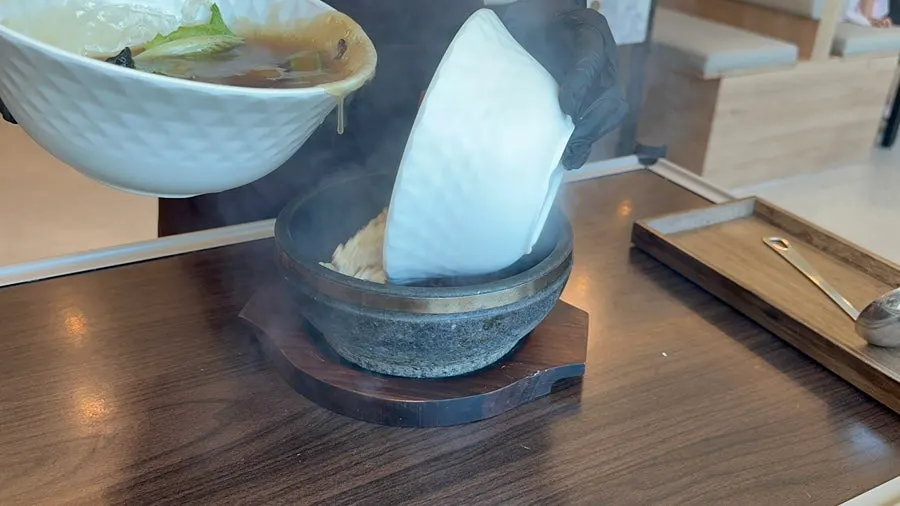 직원이 누룽지를 붓는 상차림