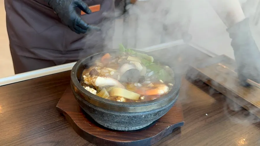 돌솥에 소스를 붓는 장면