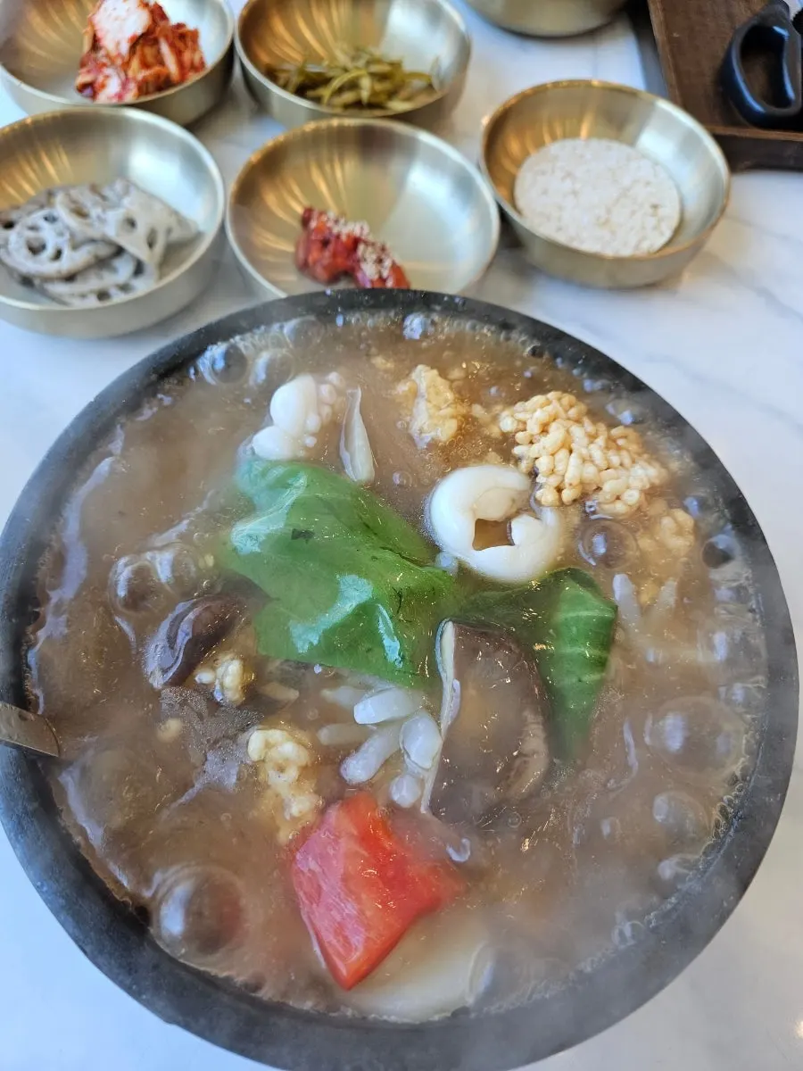 직원이 돌솥에 육수를 부어주는 장면