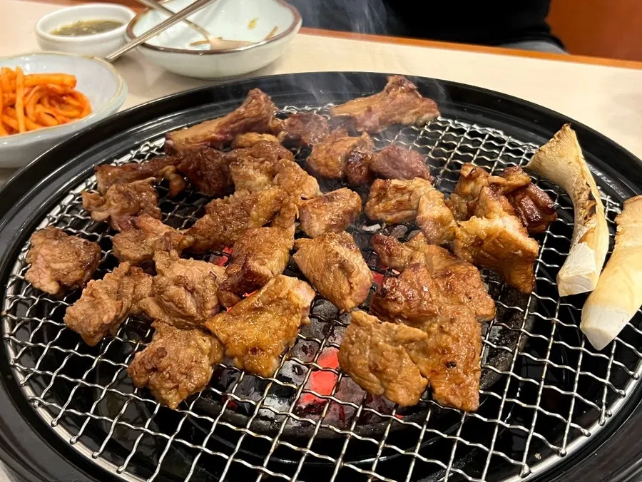 집게로 집어 든 유자숙성 돼지갈비 한 점