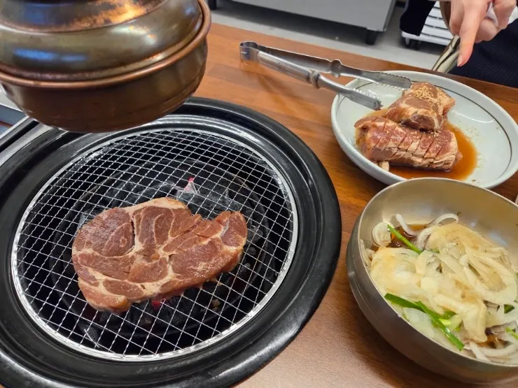 숯불 불판 위에서 익어가는 양념 고기