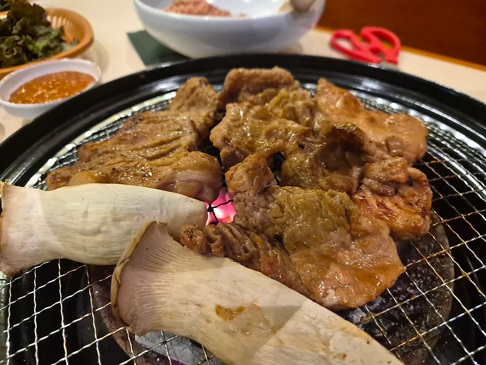 직원이 참숯 불판에 돼지갈비를 구워주는 모습