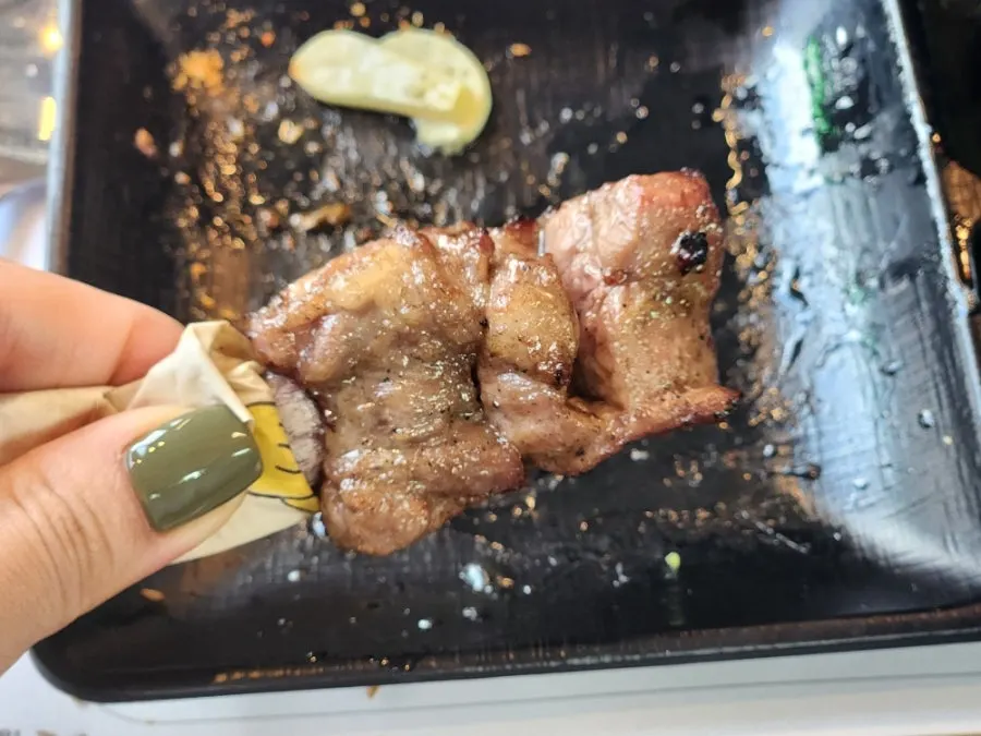 Holding a lamb rib bone with tissue while eating