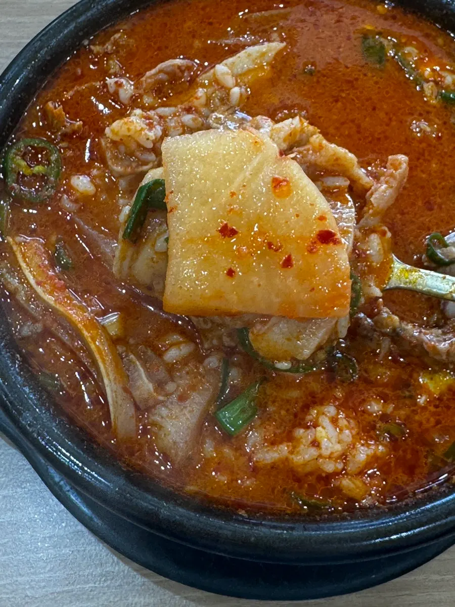 A full table setting with generous rice and spicy pork soup
