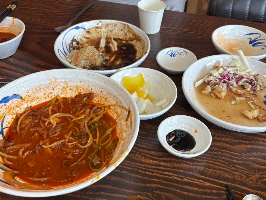 Table spread with jjambbong, fried rice, and sweet and sour pork