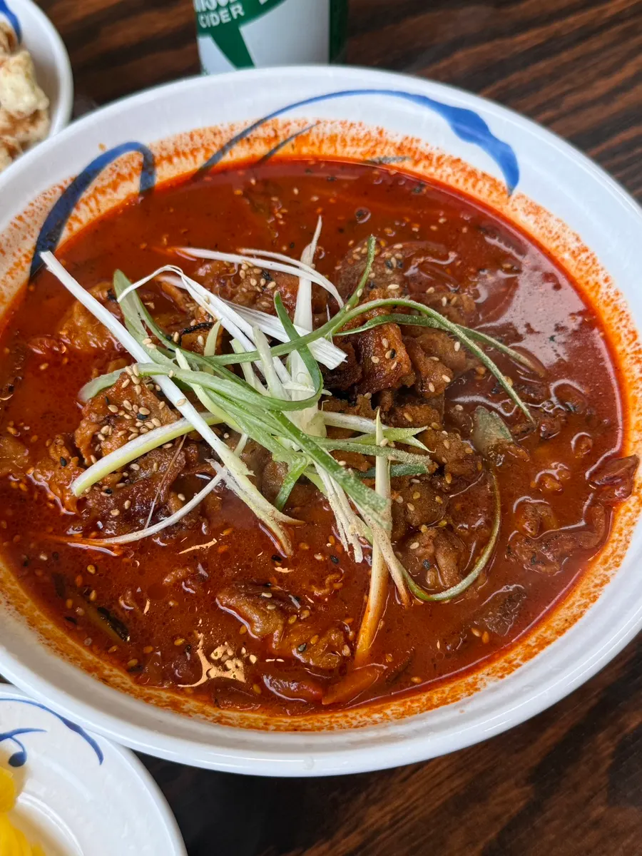 Self-serve side dish corner with kimchi, onion, and pickled radish