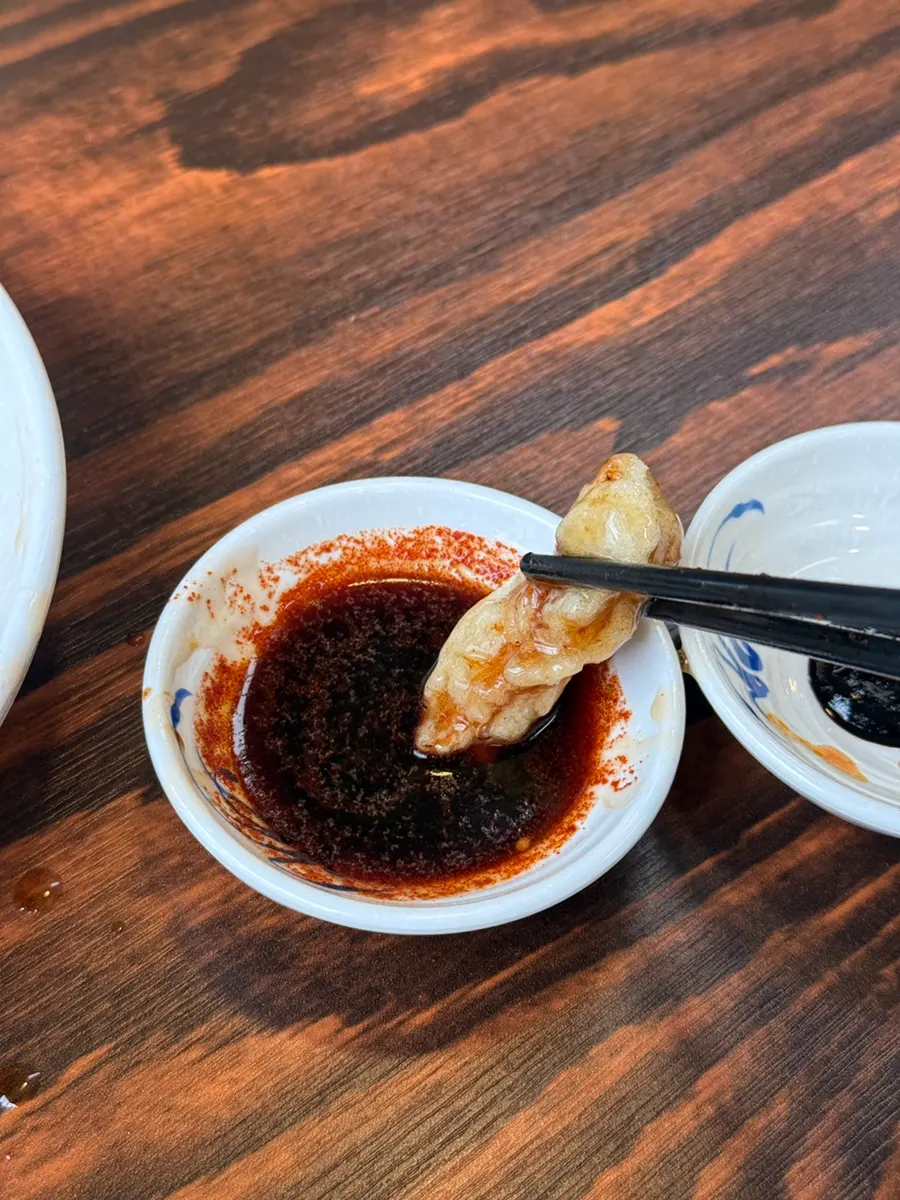 A piece of tangsuyuk dipped in soy sauce