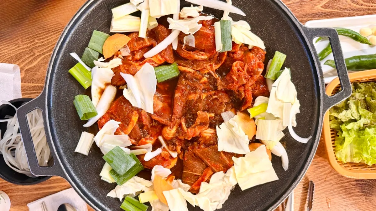Two servings of gochujang jumulleok on a griddle