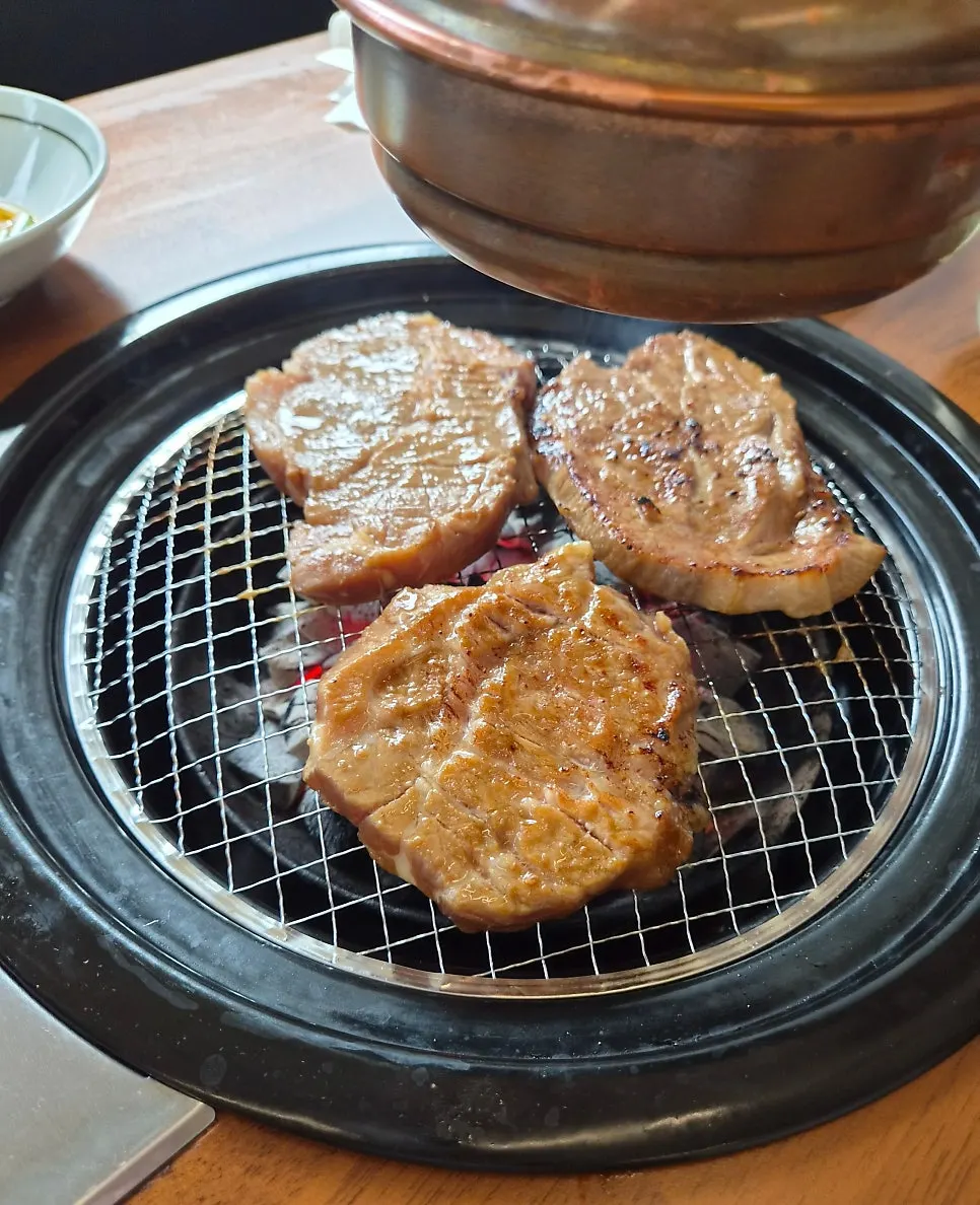 A piece of pork galbi grilled golden brown over charcoal