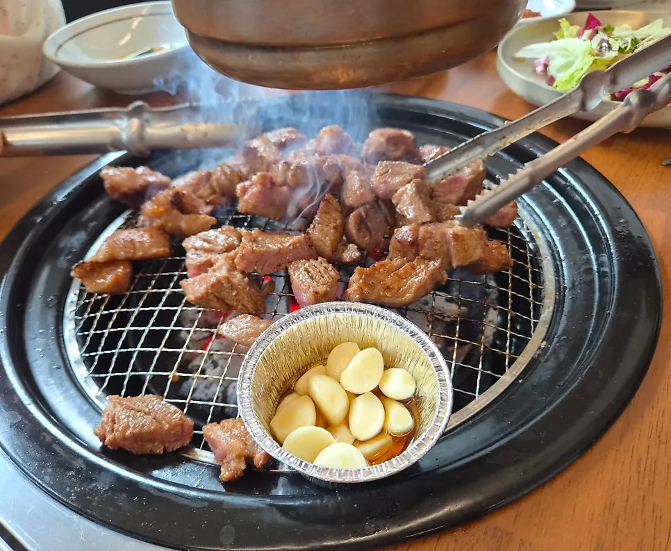 Seasoned pork galbi grilling over charcoal