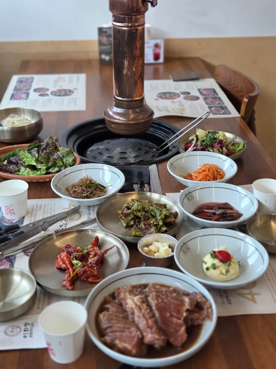 Ihwajeong's spread of banchan including seasoned crab and japchae