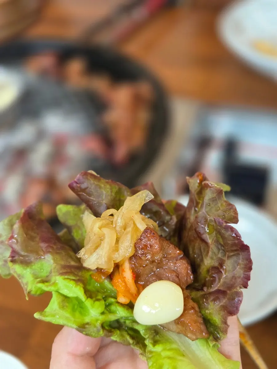 Lettuce wrap topped with grilled garlic and radish salad