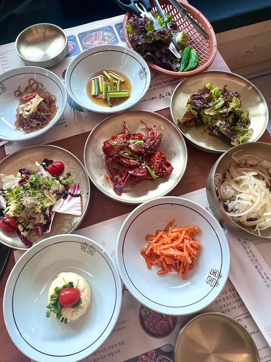 Spread of basic banchan including japchae and mu-saengchae