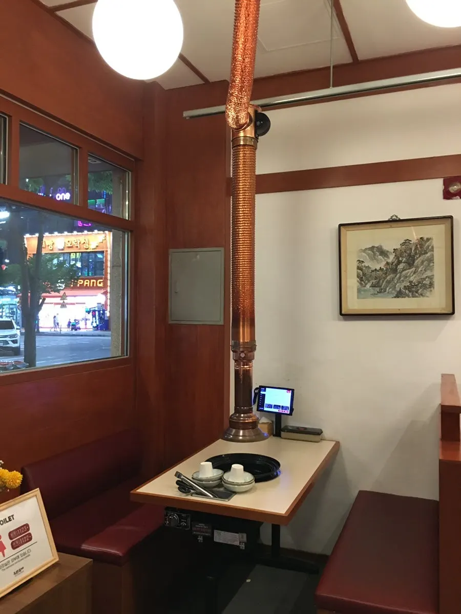 Dining hall seating with wide table spacing at Okryeon Galbi