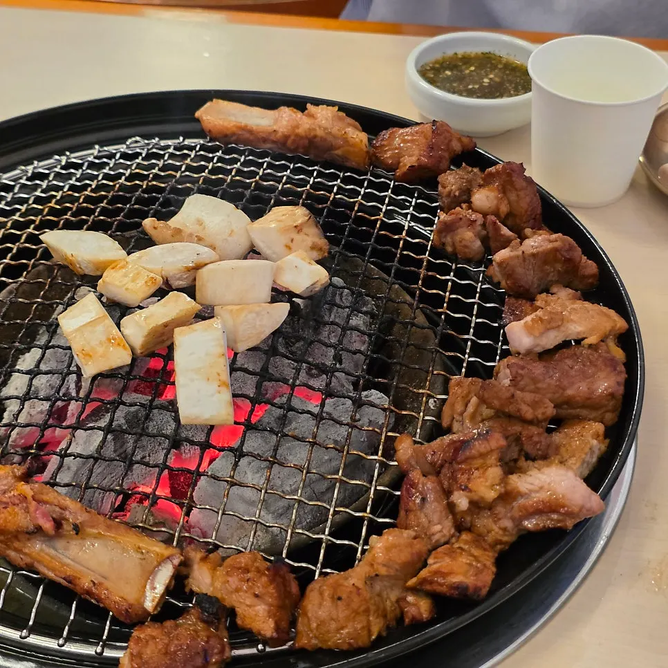 A piece of black pork seasoned galbi dipped in yuzu sauce