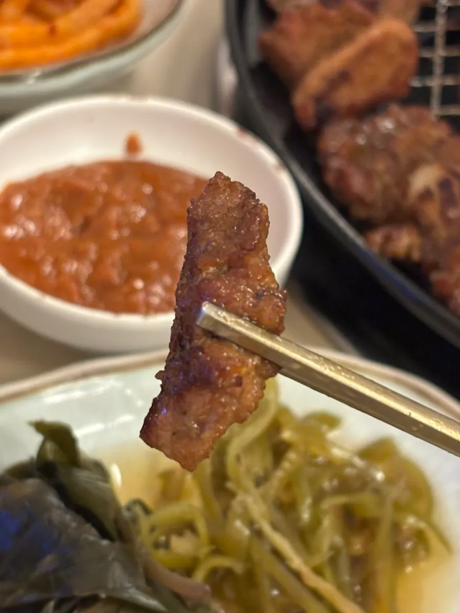 소스에 찍은 돼지갈비 한 점