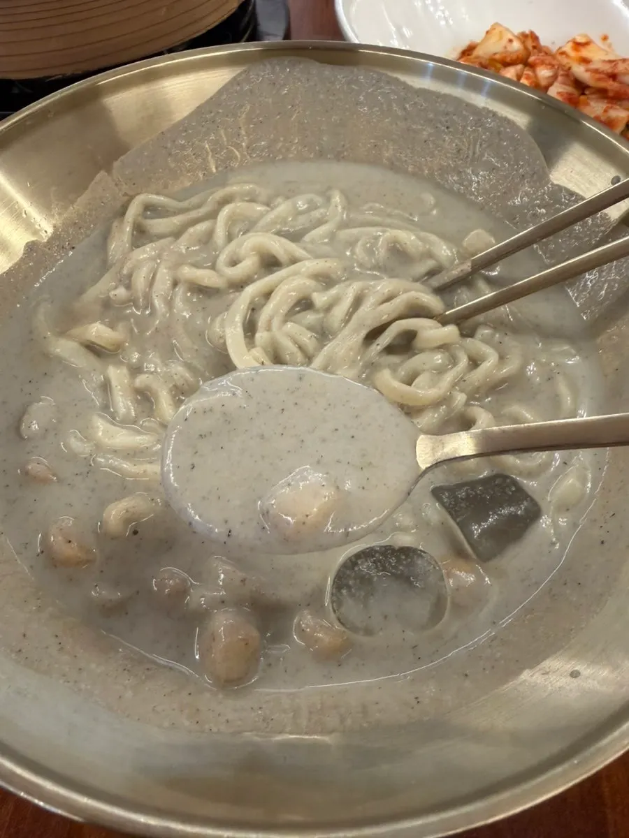Chewy kalguksu noodles lifted with chopsticks
