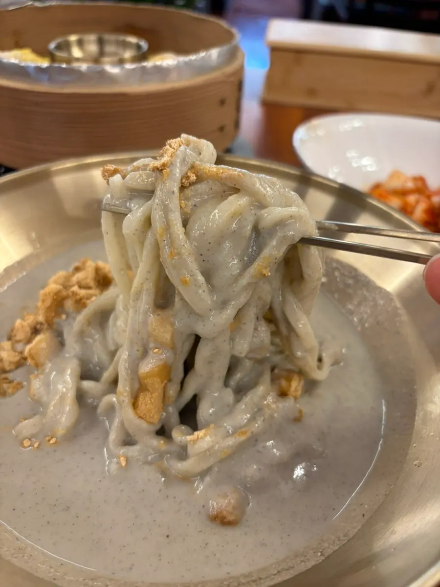 Eating the soybean kalguksu together with dumplings