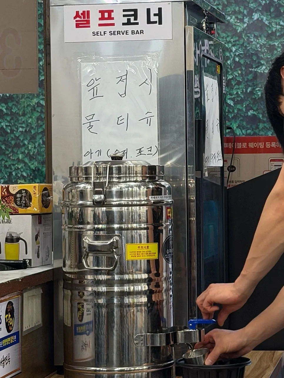 Self-serve warm broth dispenser by the entrance of Seoul Myeonok