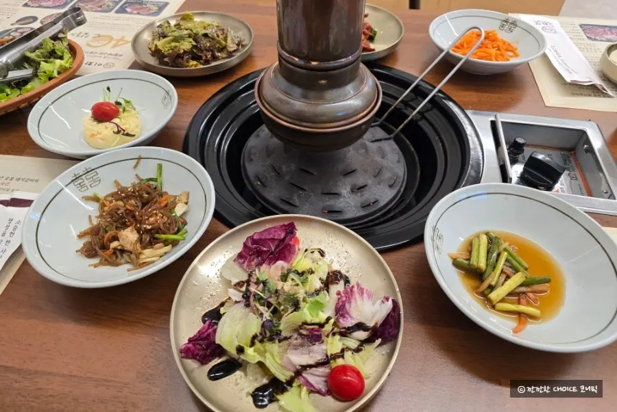 Table of basic banchan including seasoned crab and japchae