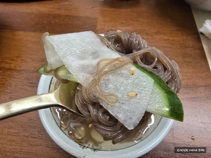 Mul naengmyeon served alongside grilled meat
