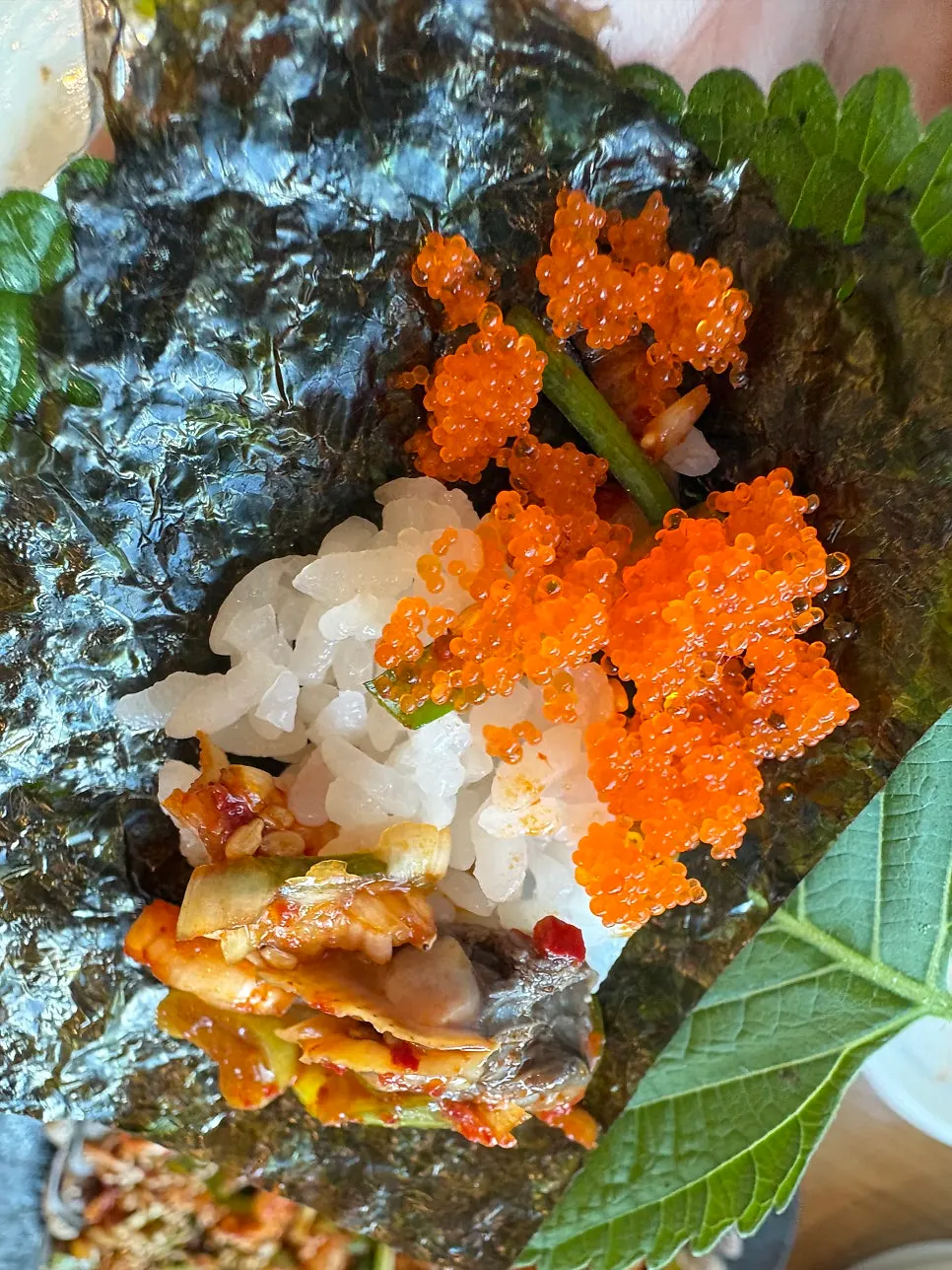 A bite of seasoned cockles wrapped in laver