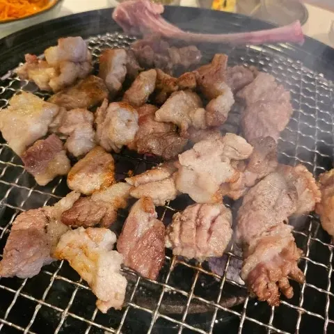 Thick black pork raw galbi cooking over charcoal