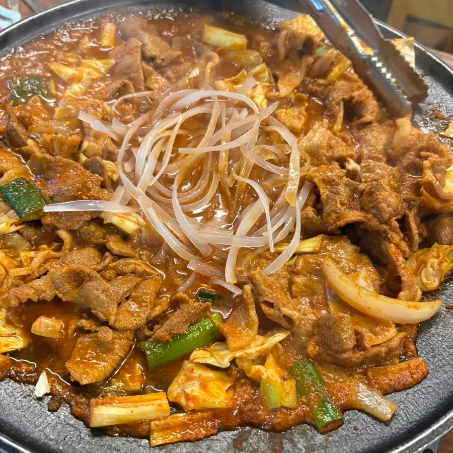 Gochujang-seasoned meat topped with green onion and cabbage