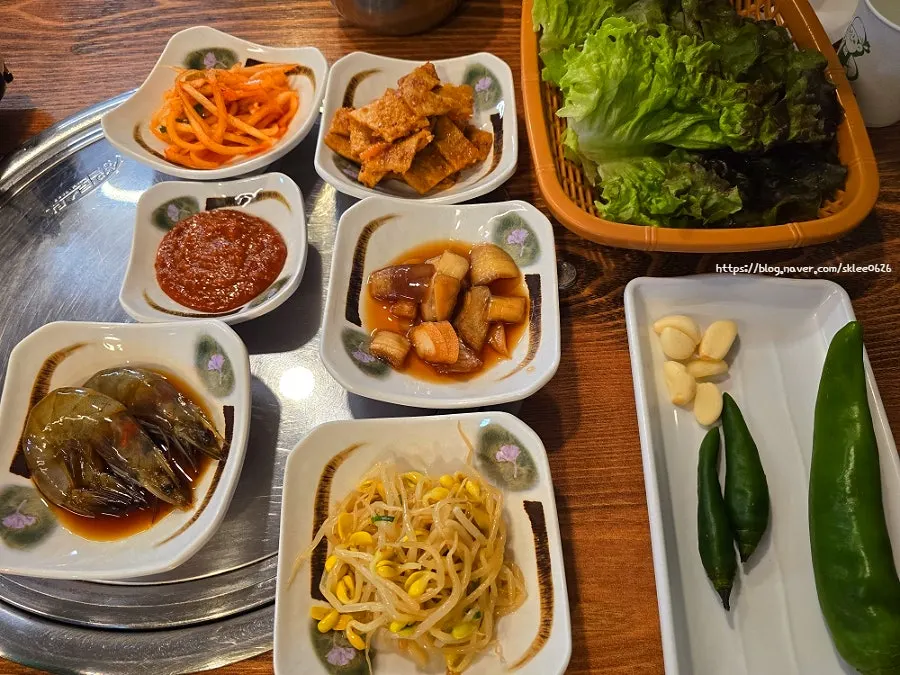 Side dishes including lettuce, garlic, and pickled onion