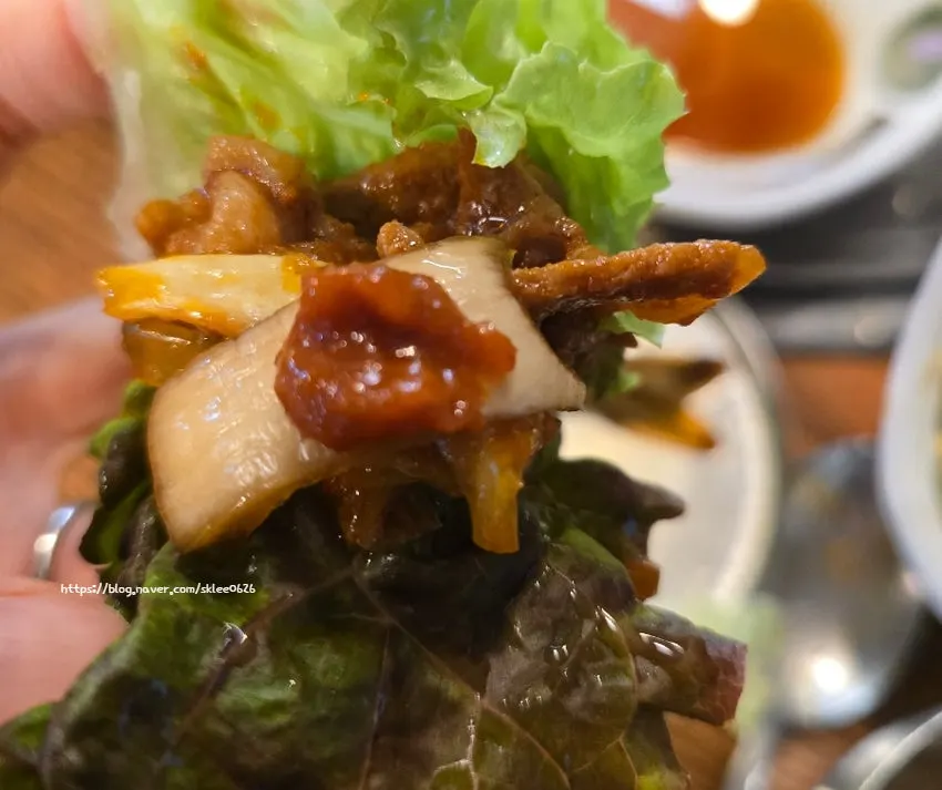 Lettuce wrap of gochujang jumulleok topped with seasoned bean sprouts
