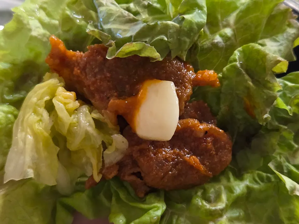 Wrapping the cooked jumulleok in a ssam wrap