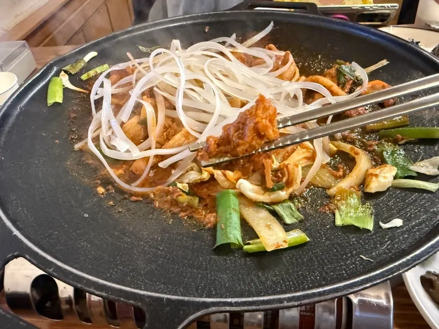 Female Korean beef jumulleok cooking on the grill