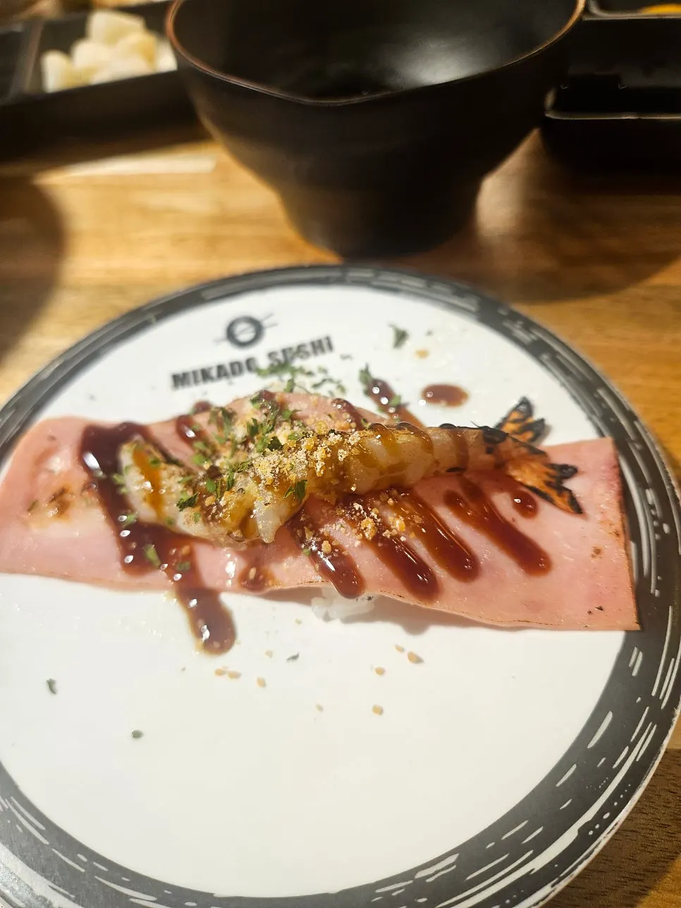 A plate with two pieces of raw fish sushi