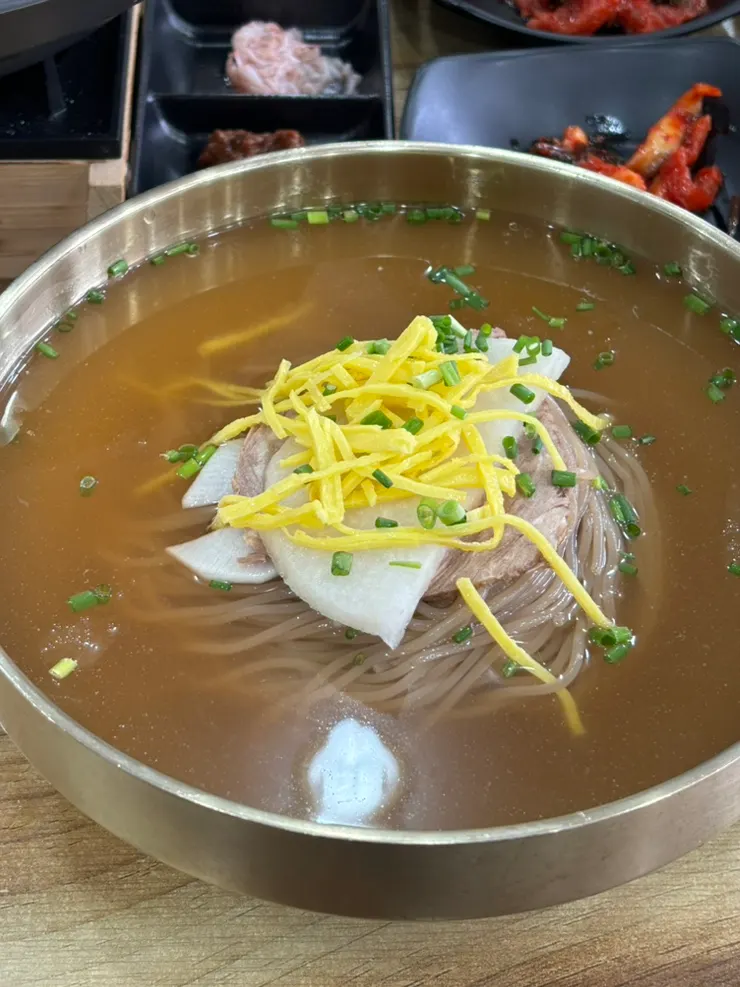 Naengmyeon toppings of pear, egg garnish and green onion