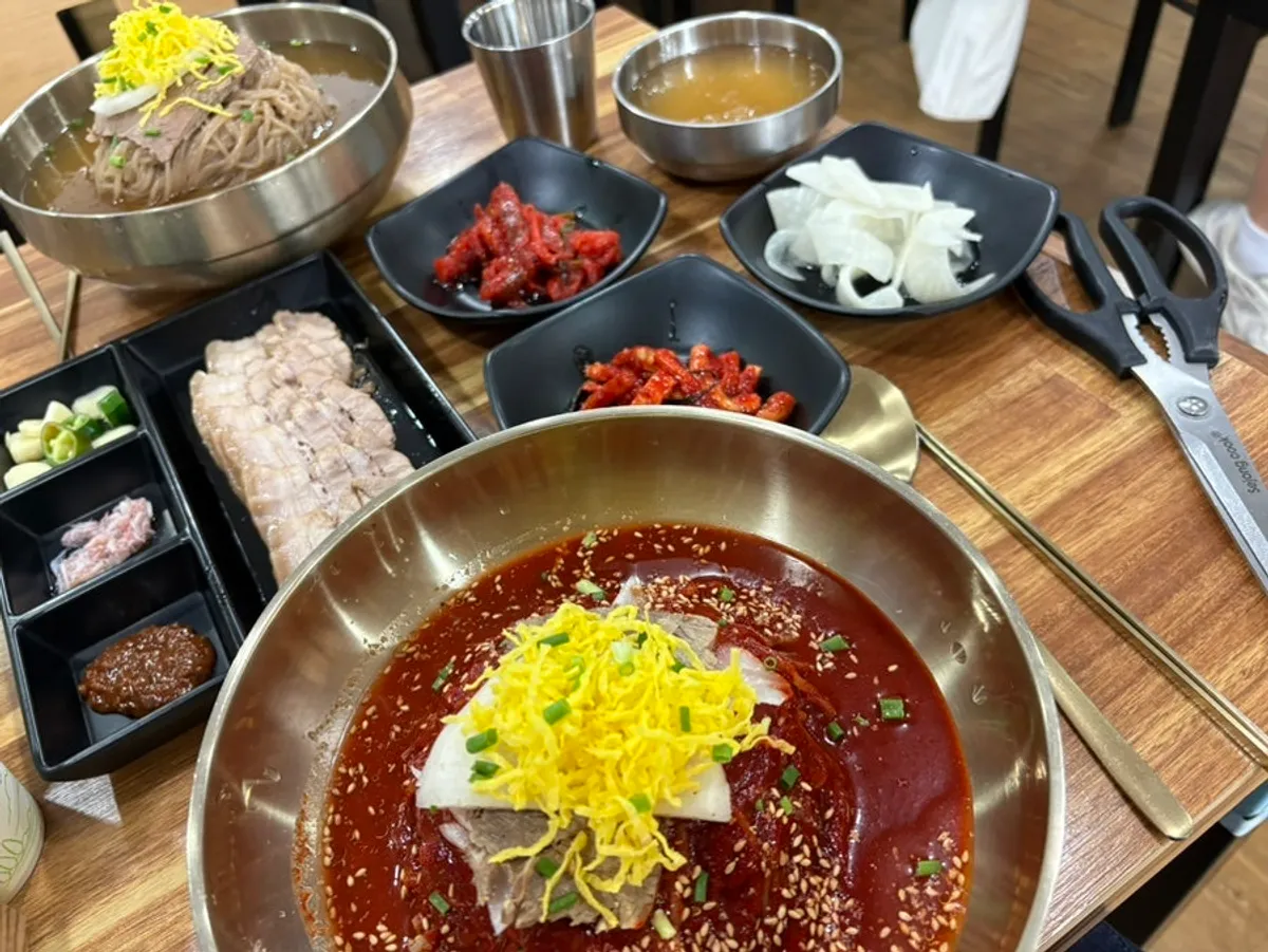Full table setting of pyongyang naengmyeon and bibim naengmyeon at Seoul Myeonok