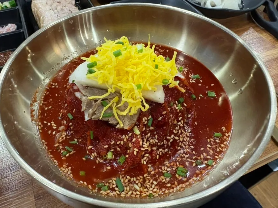 Seoul Myeonok's bibim naengmyeon topped with sauce
