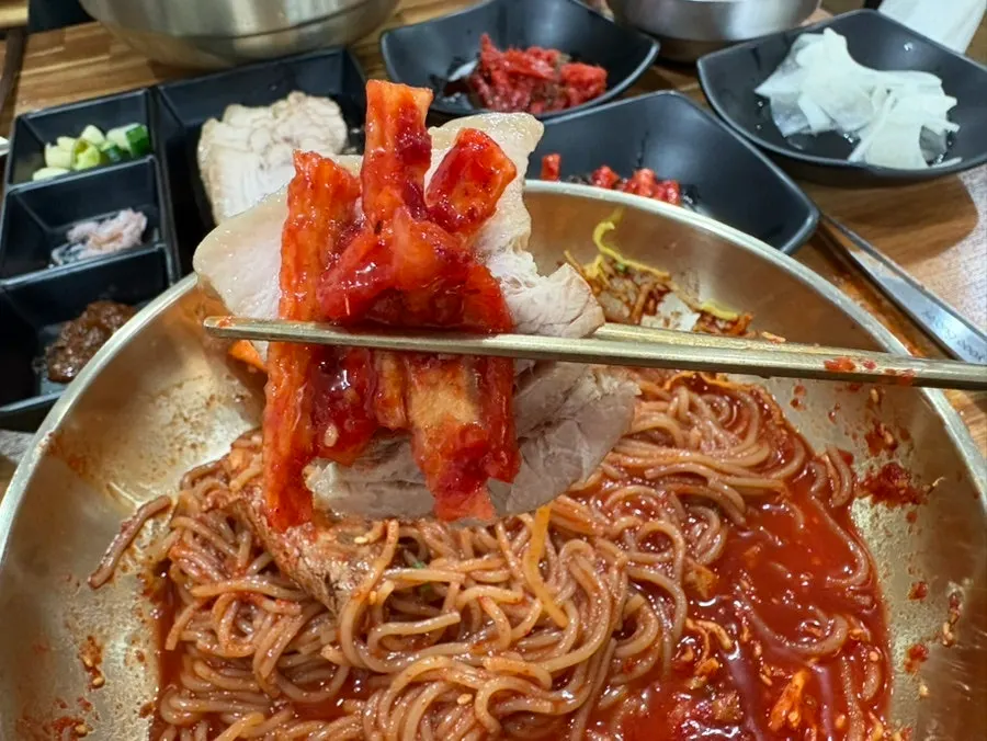 A piece of suyuk with bibim naengmyeon