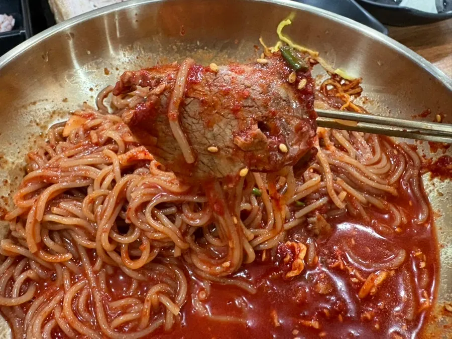 Naengmyeon topped with large chunks of meat